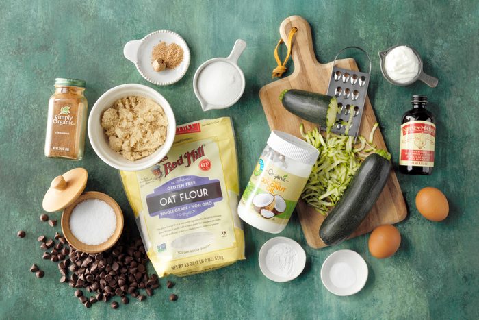 ingredients for gluten free zucchini bread on a green surface, top view
