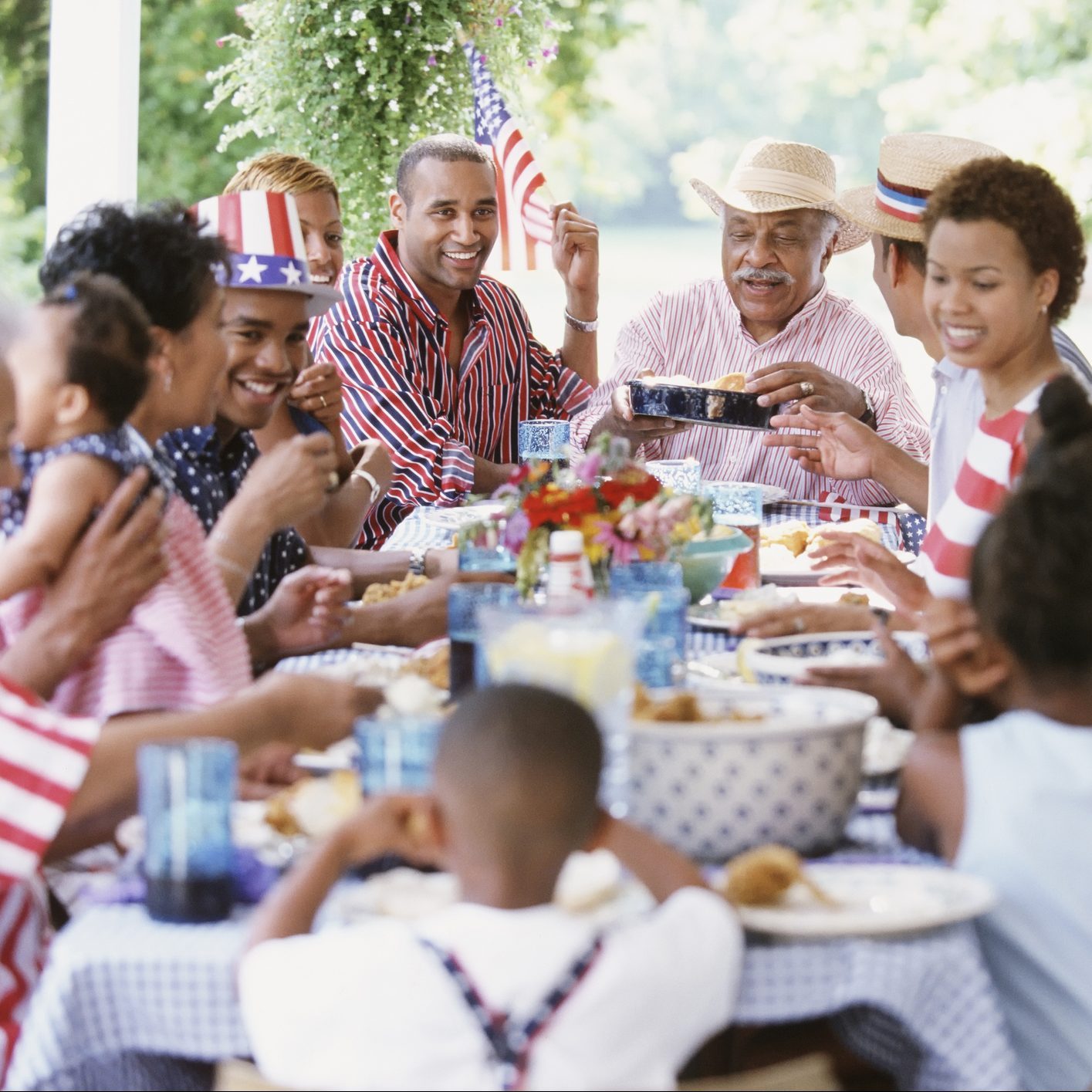 Multi-generation Black family eating at Fourth of July barbecue