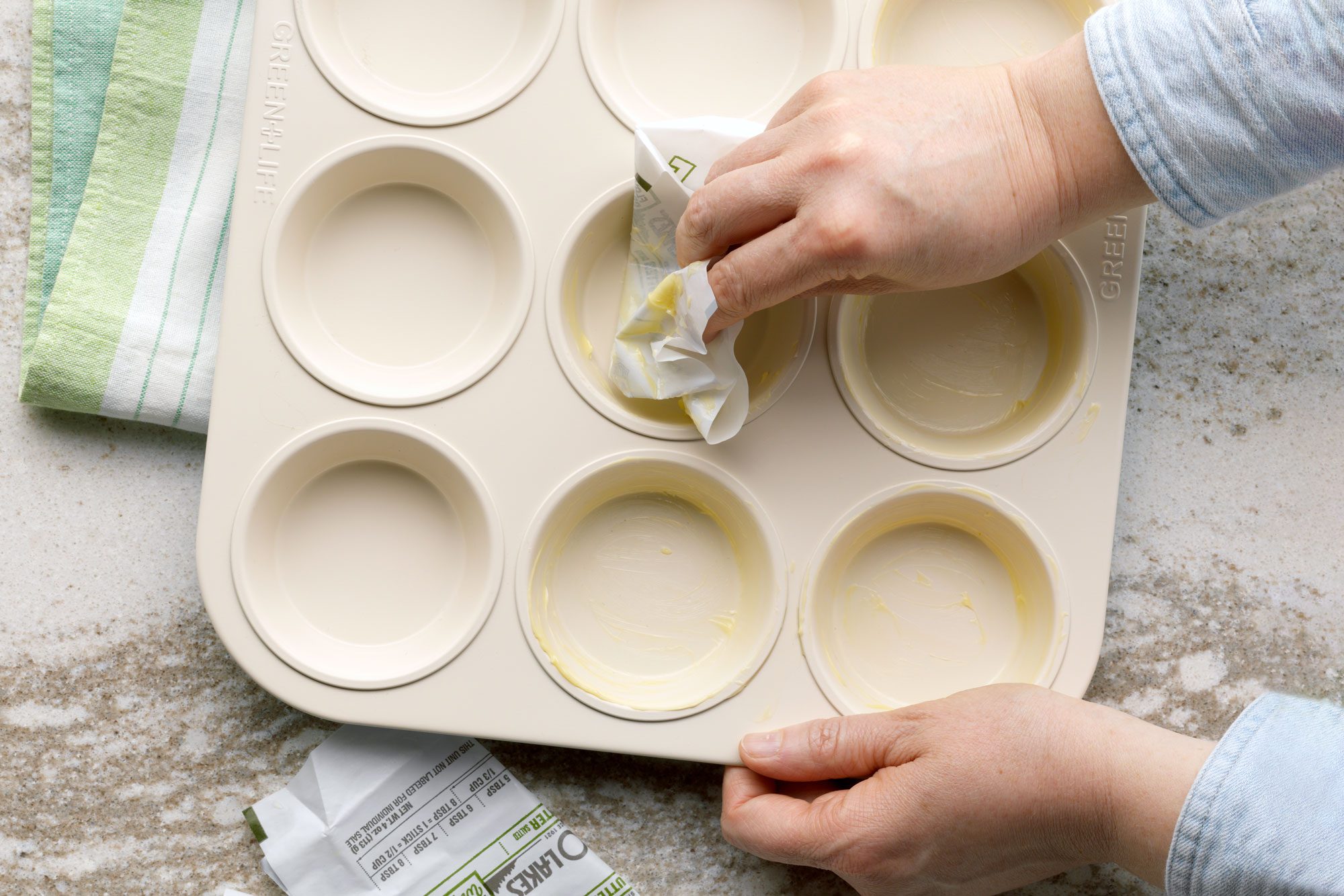 hands Greasing A baking Pan With a Butter Paper wrapper