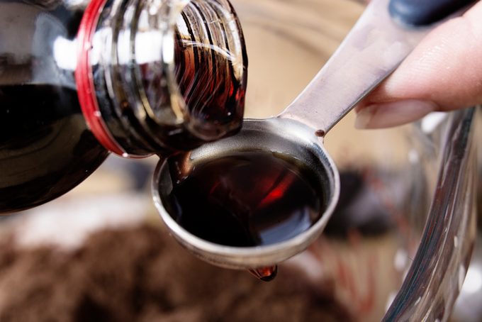 Close-up of vanilla extract being poured onto a teaspoon