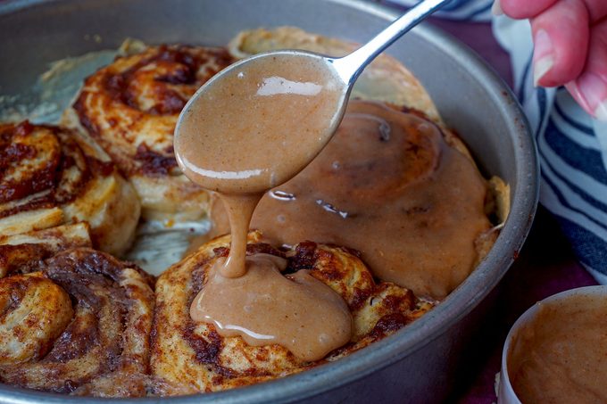 Drizzling spice mix on cinnamon rolls