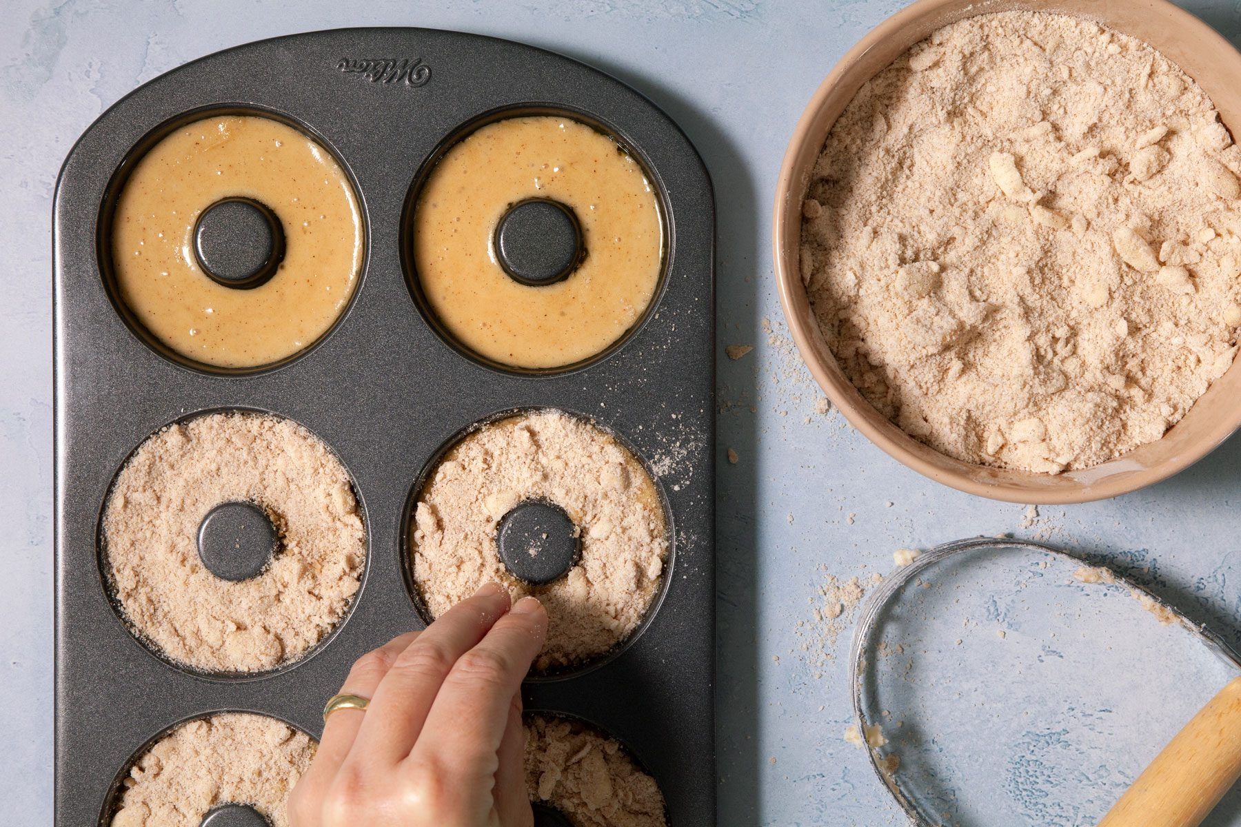 A Person Putting Dough Into a Muffin Tin