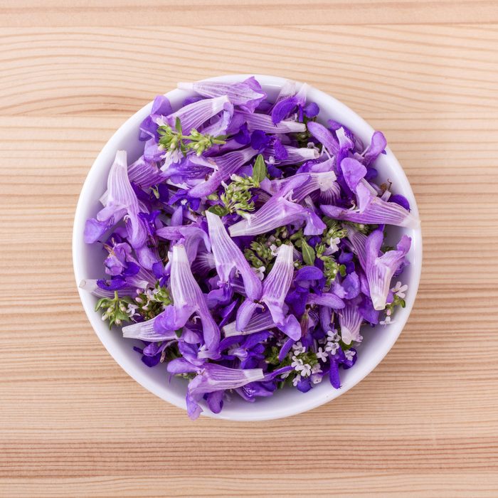 violets in a bowl on a wooden table