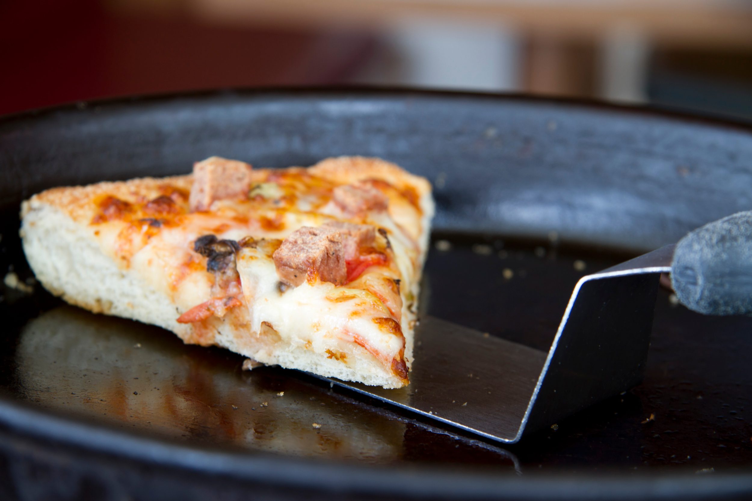 slice of pizza being removed from a pan