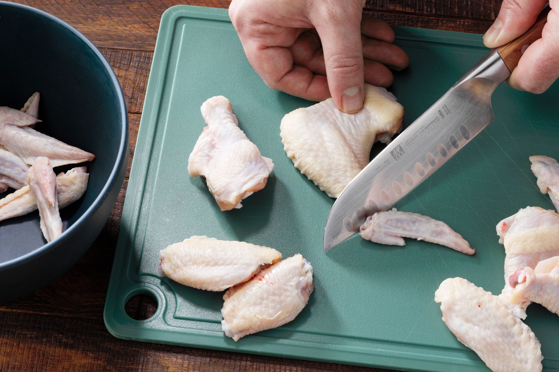 A person using knife to separate the wings
