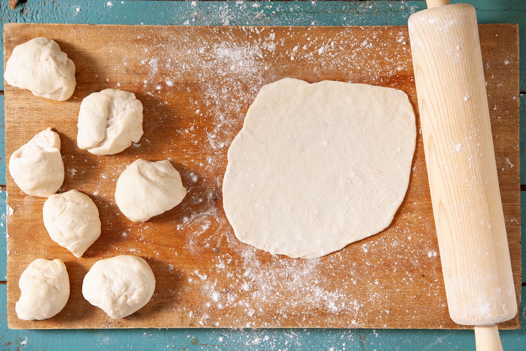 Rolled out dough on wooden surface with flour on it