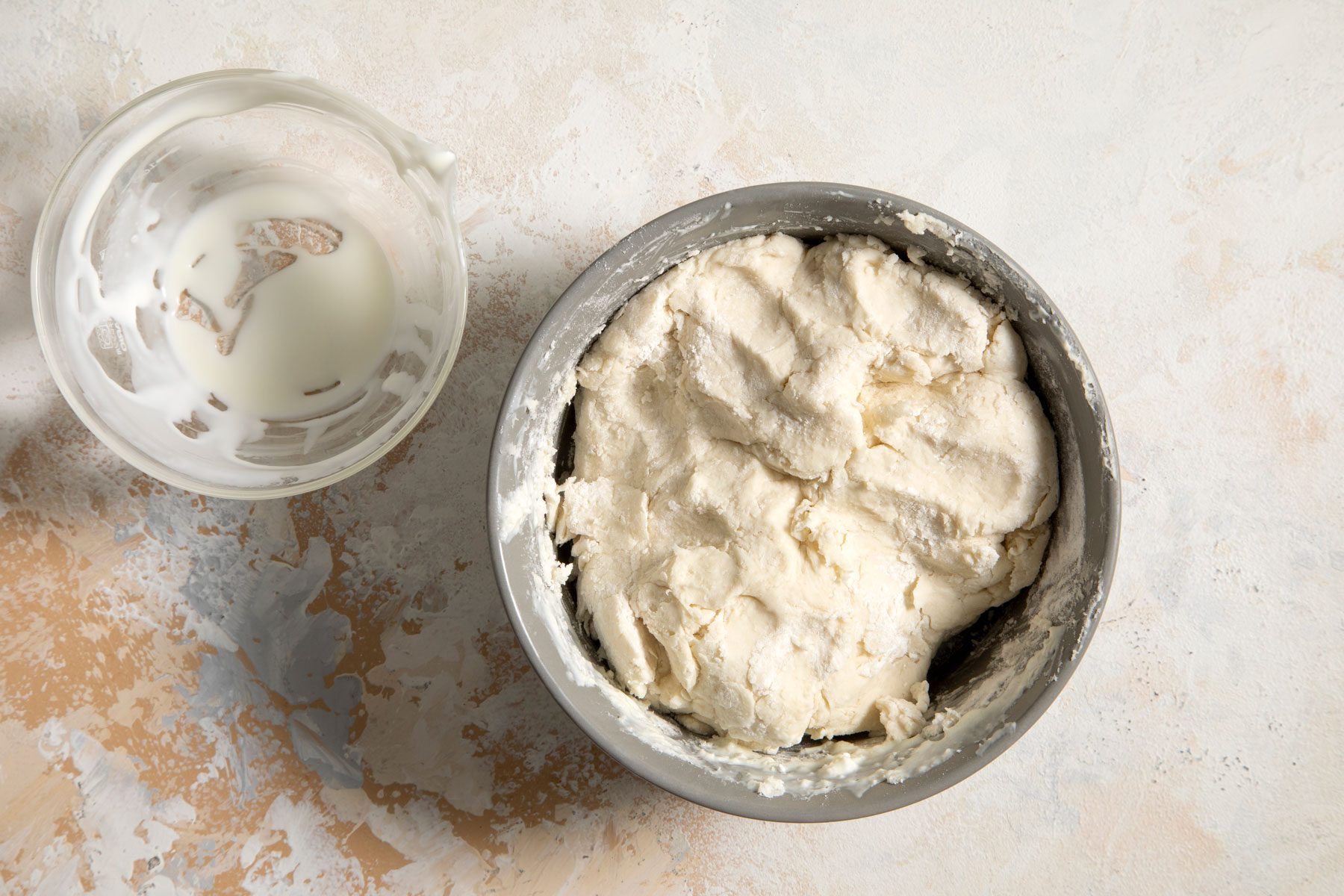 Dough in a large bowl on a marble surface