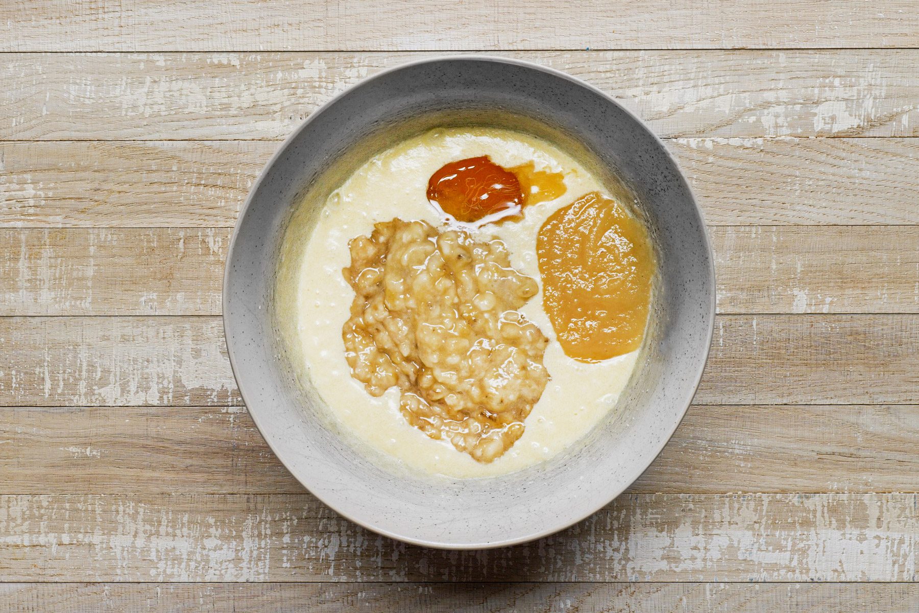 A bowl of bananas, applesauce, honey with egg mixture.