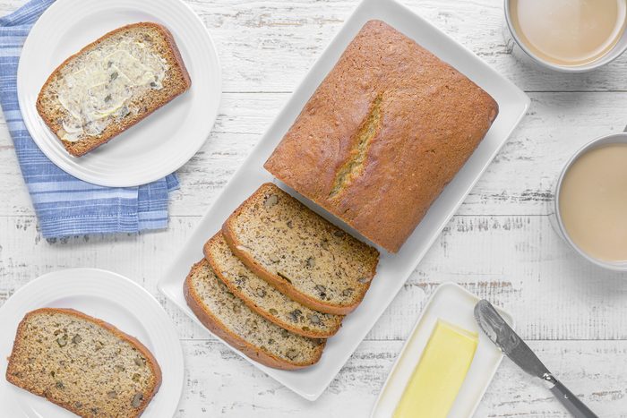 Banana Walnut Bread in a small ceramic tray on white painted wooden surface