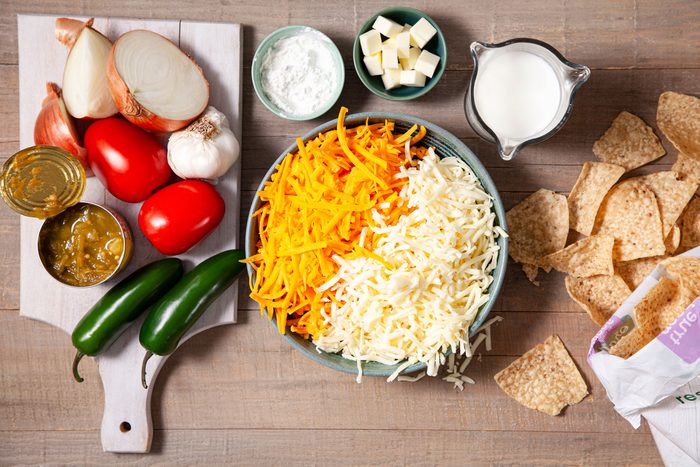 Green chilli, onion and other ingredients on a wooden table to prepare Chili Con Queso