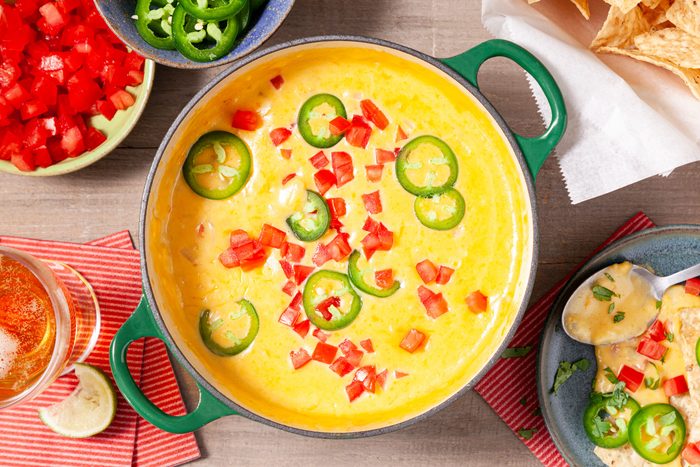 Chili Con Queso in a big bowl served with chips and drink