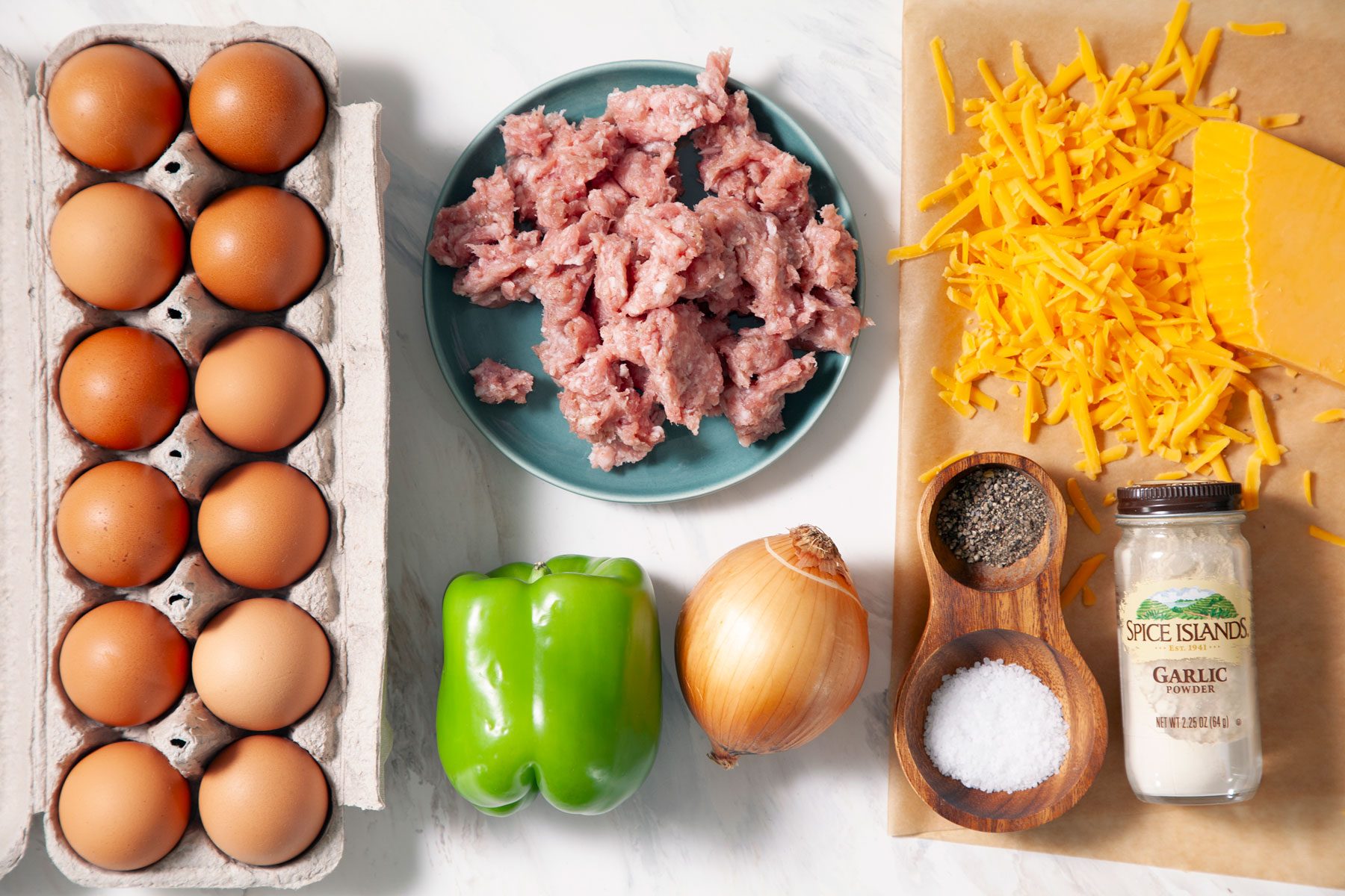 Eggs vegetables Pork sausage and other ingredients on a marble surface