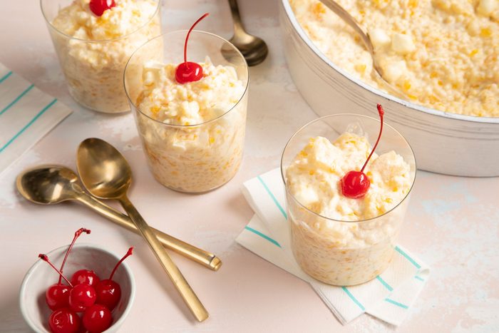 Frog Eye Salad Served in dessert cups garnished with cherries; golden spoons; a small bowl of cherries;