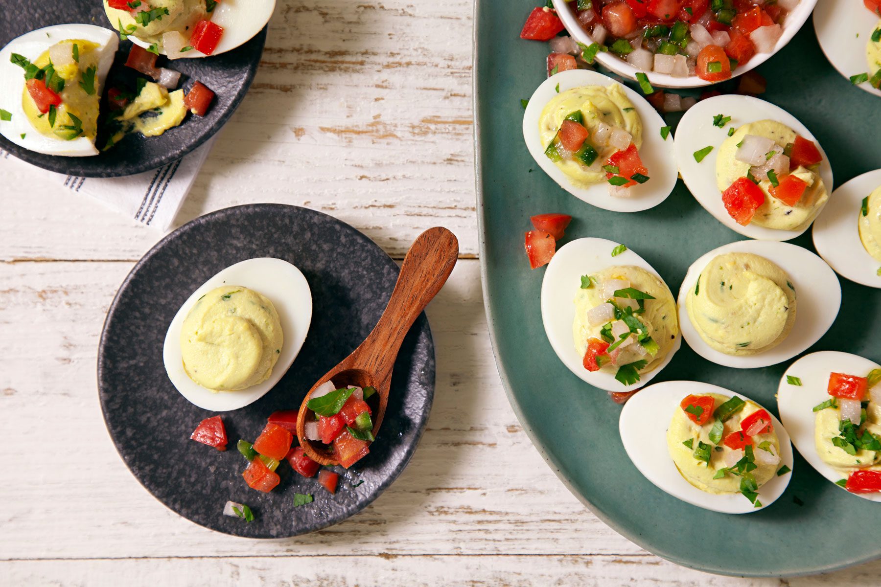 Guacamole Deviled eggs served in a plate with a wooden spoon
