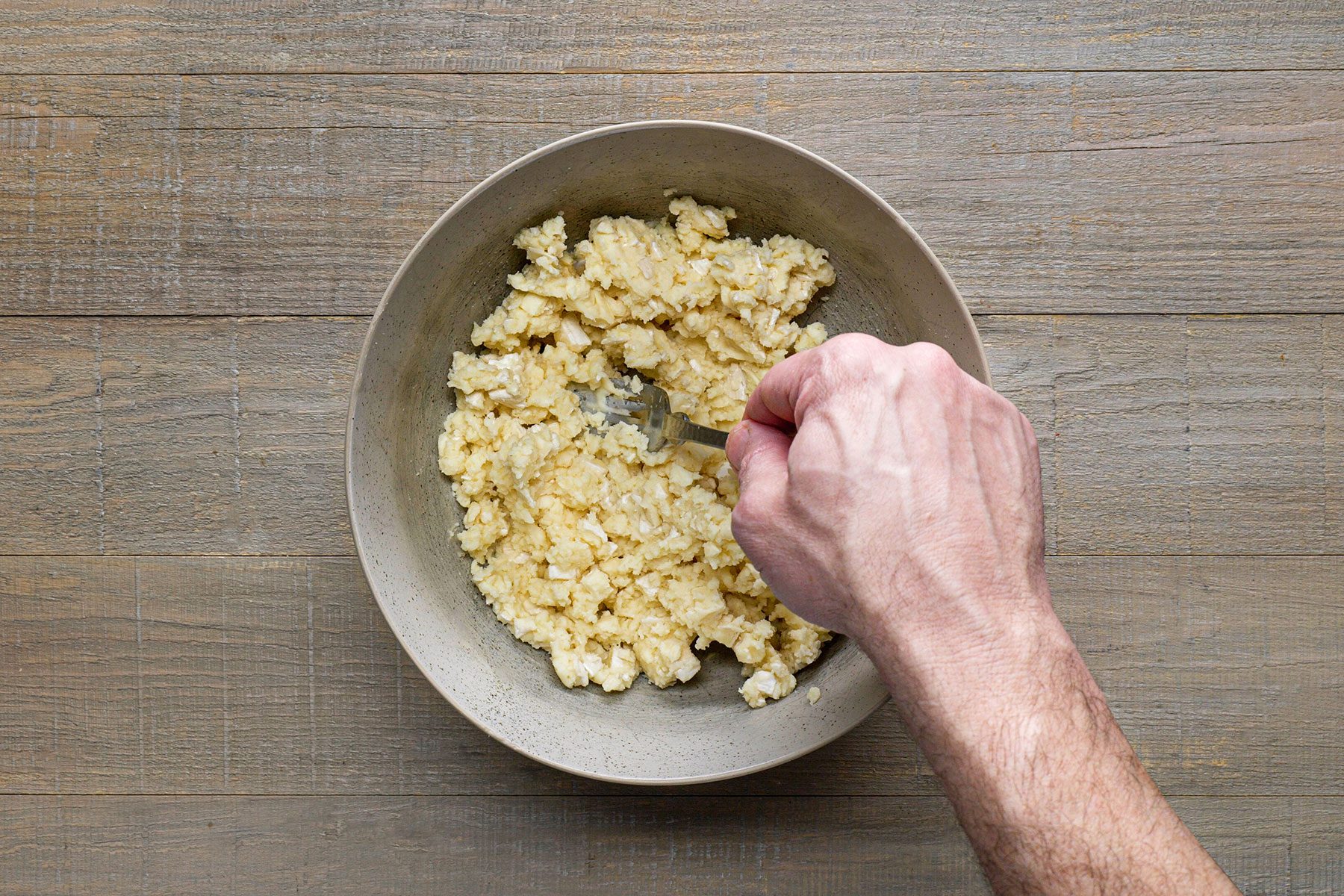 Mashing Camembert cheese with a fork