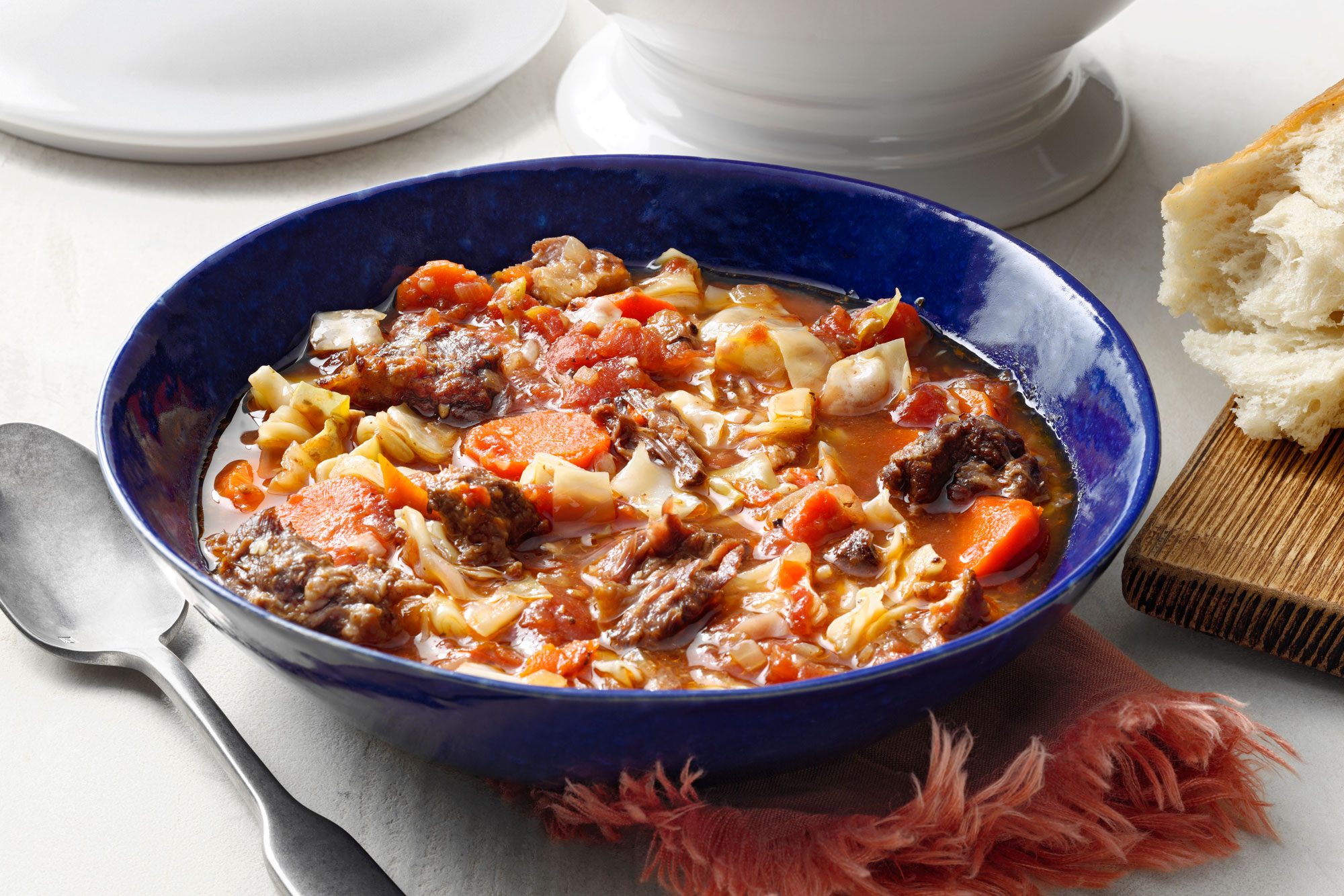 Oxtail Soup served in a blue bowl with spoon