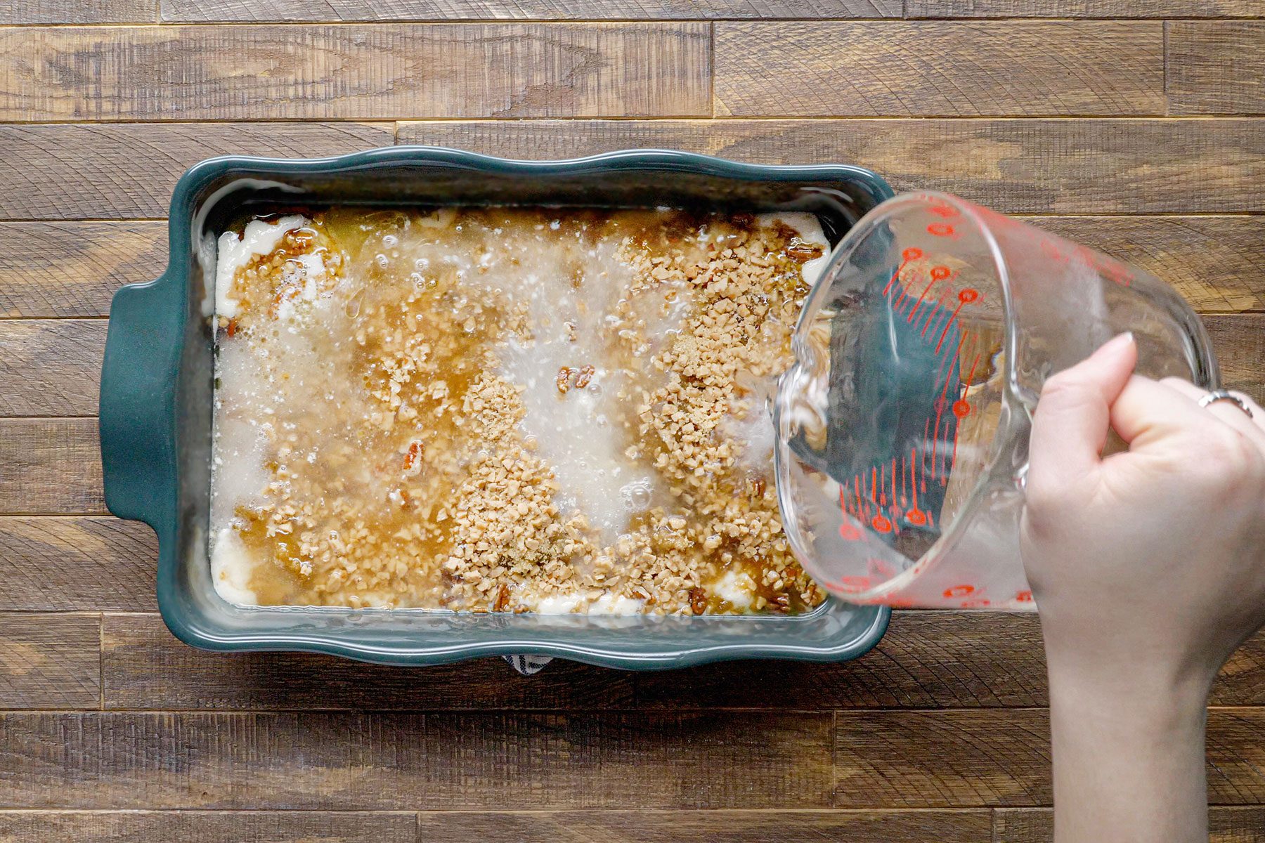 Adding water over batter in blue baking tray