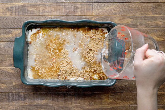 Adding water over batter in blue baking tray