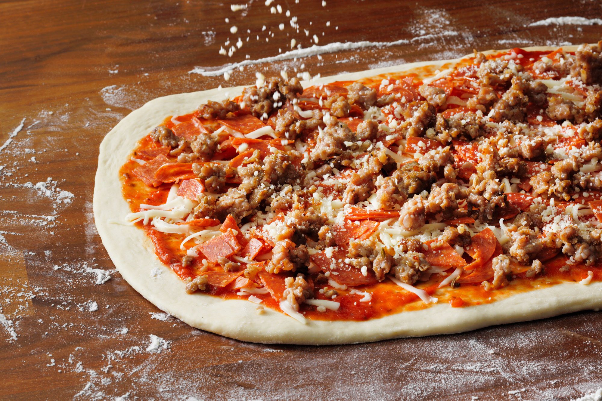 Sprinkle with mozzarella cheese, pepperoni, sausage and Parmesan cheese