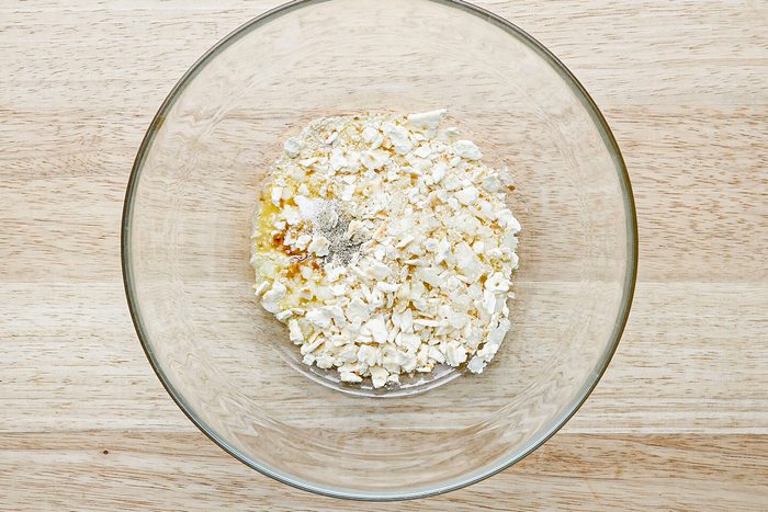 dry ingredients for salmon patties ready to mix in a glass bowl on a wooden surface