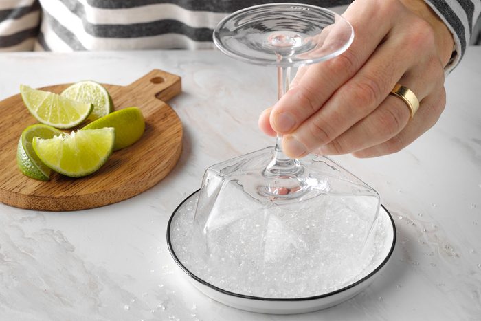 Dipping the glass into sugar spread to coat the glass rim