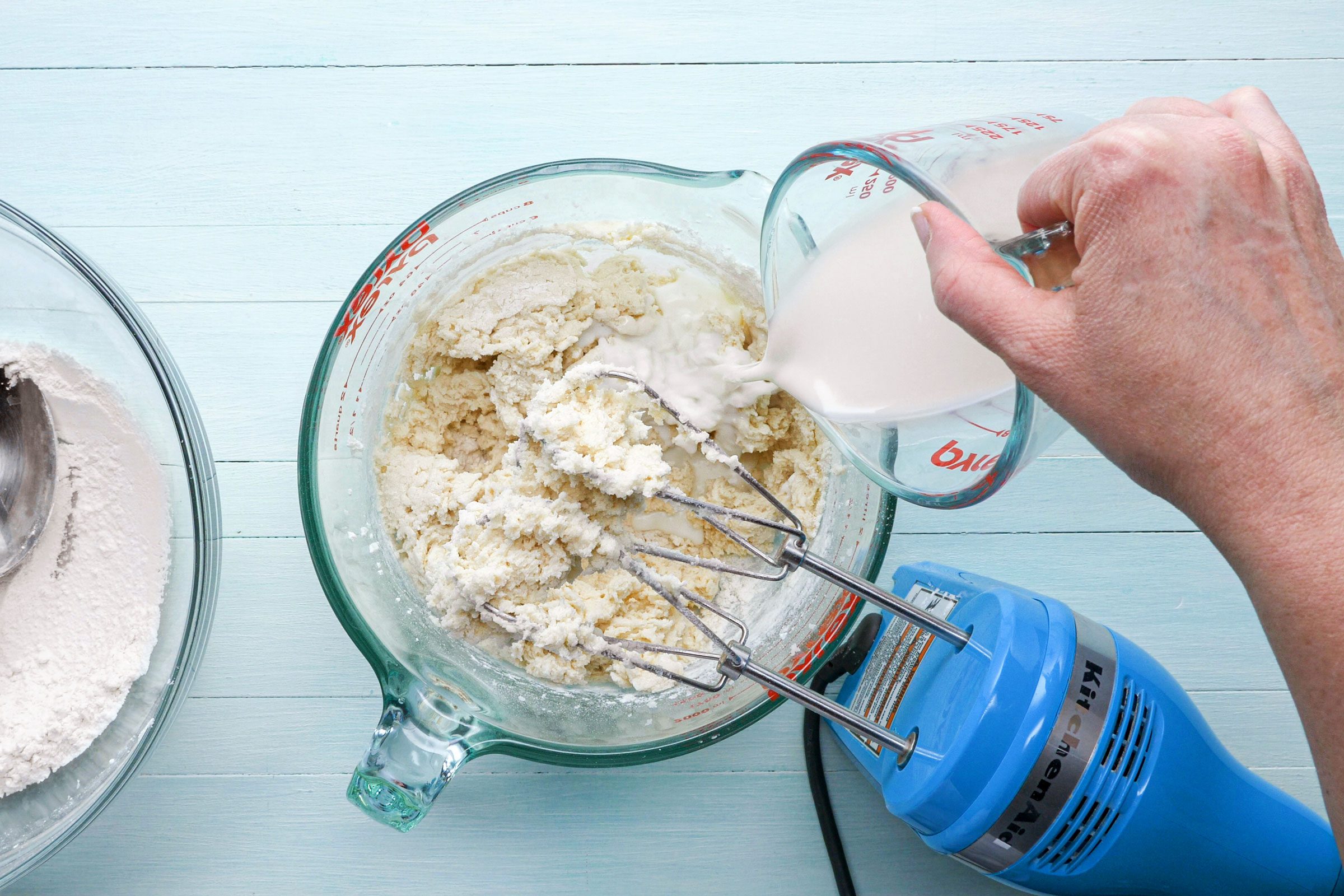 pouring milk into creamed butter