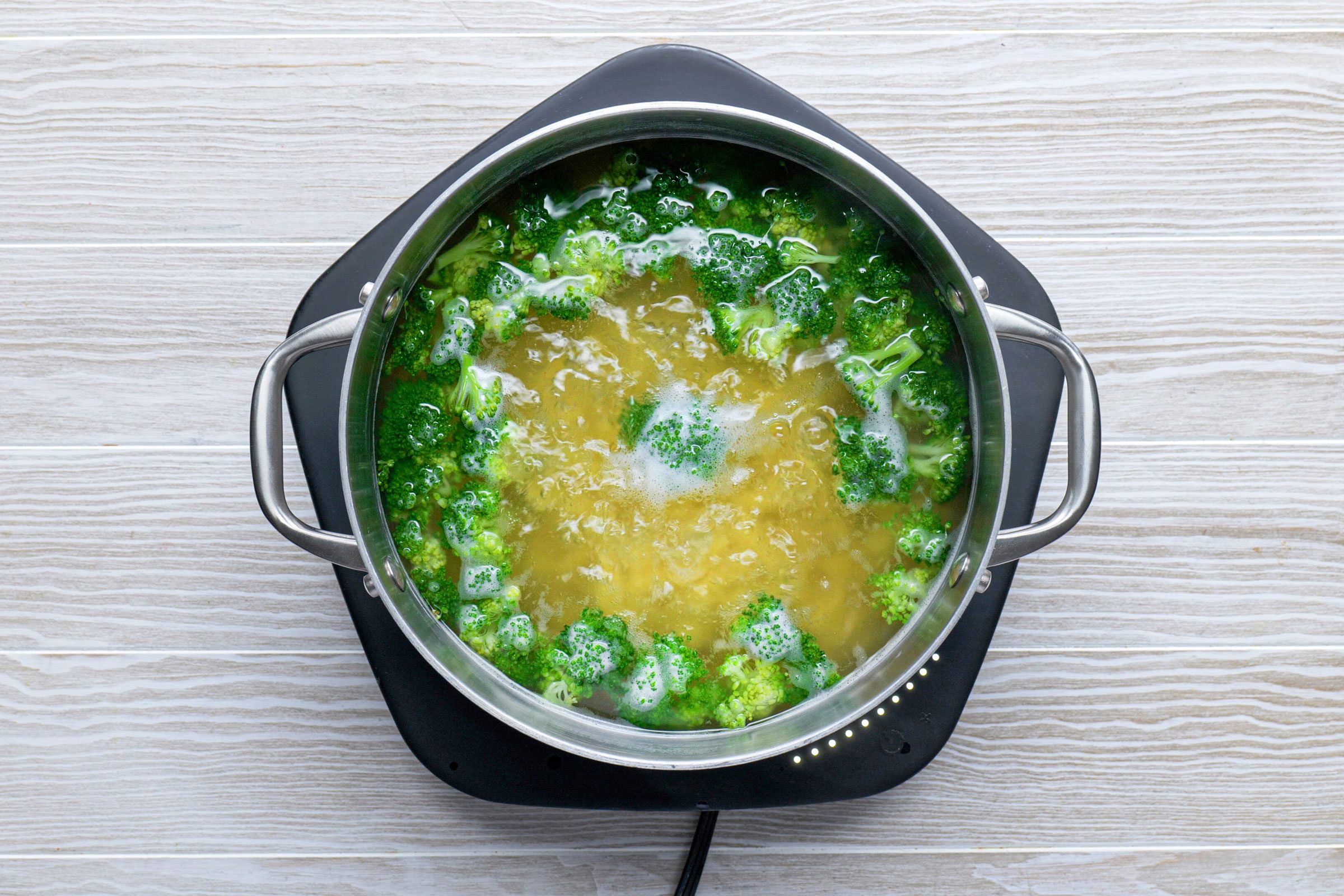 cooking broccoli in water on a hot plate