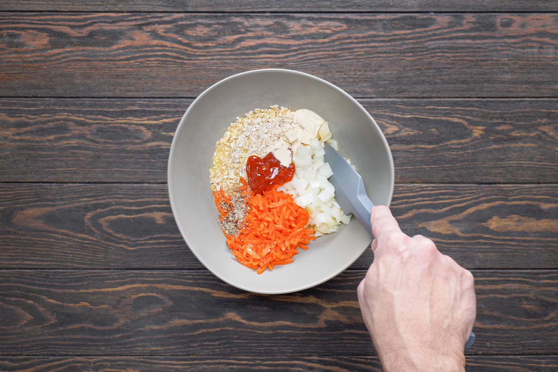 Mixing chopped vegetables and spices in a large bowl