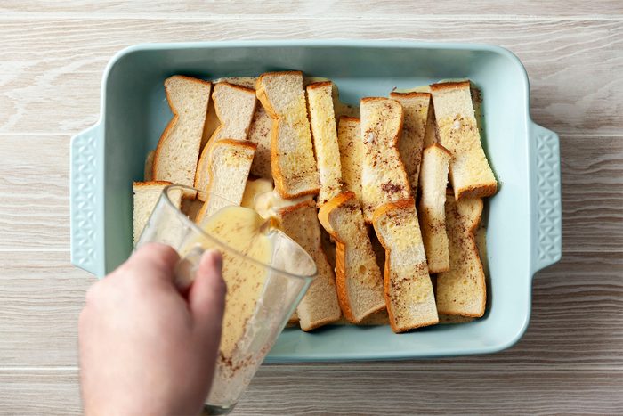 Pouring the egg mixture in to sliced Bread
