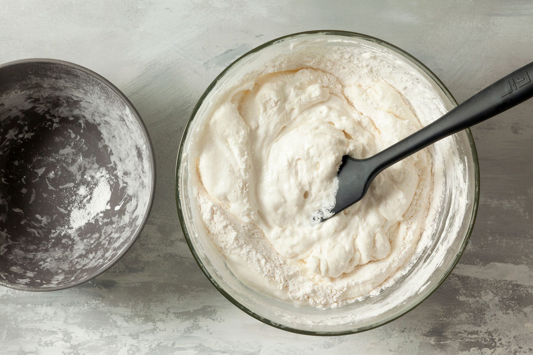 Flour and cream mixed inside a bowl on a kitchen countertop