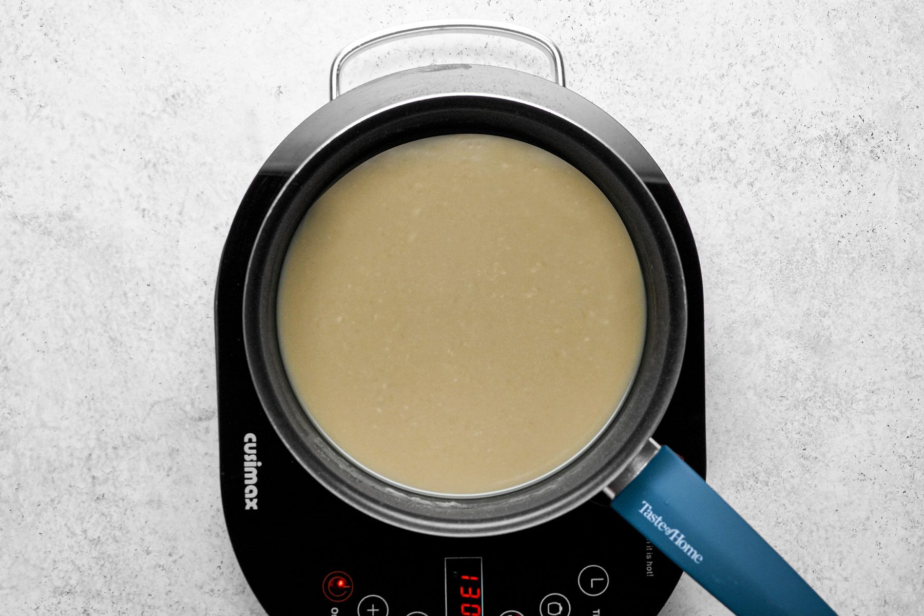 Olive color mixture sauce cooking in large skillet