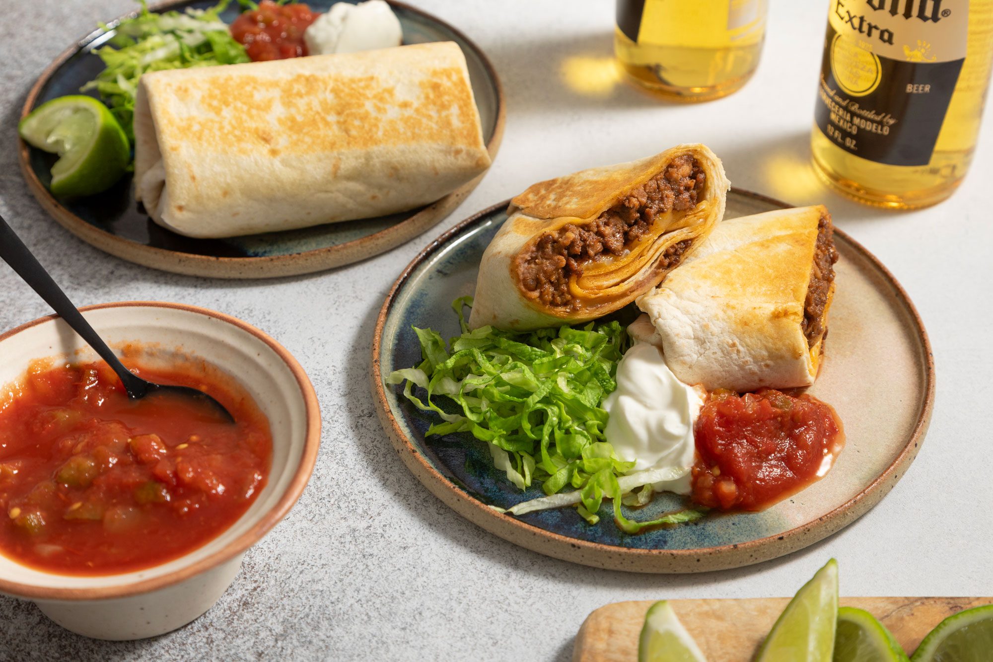 Burritos with sour cream and salsa served on small round plates