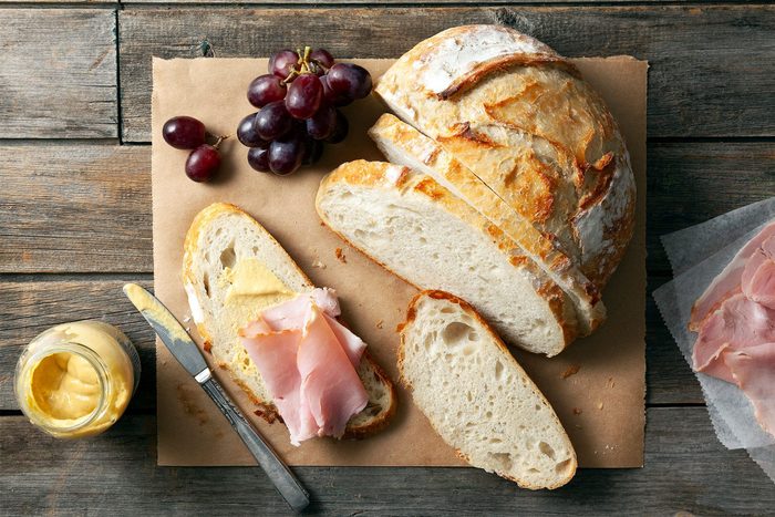 Crusty Homemade Bread served with meat slices on wooden base