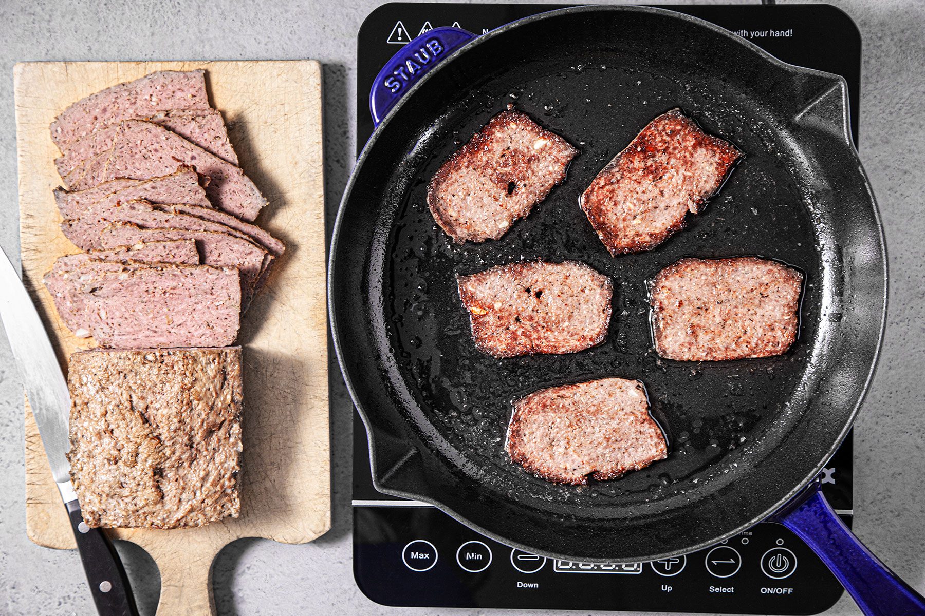 Sliced pieces of meat cooking in skillet