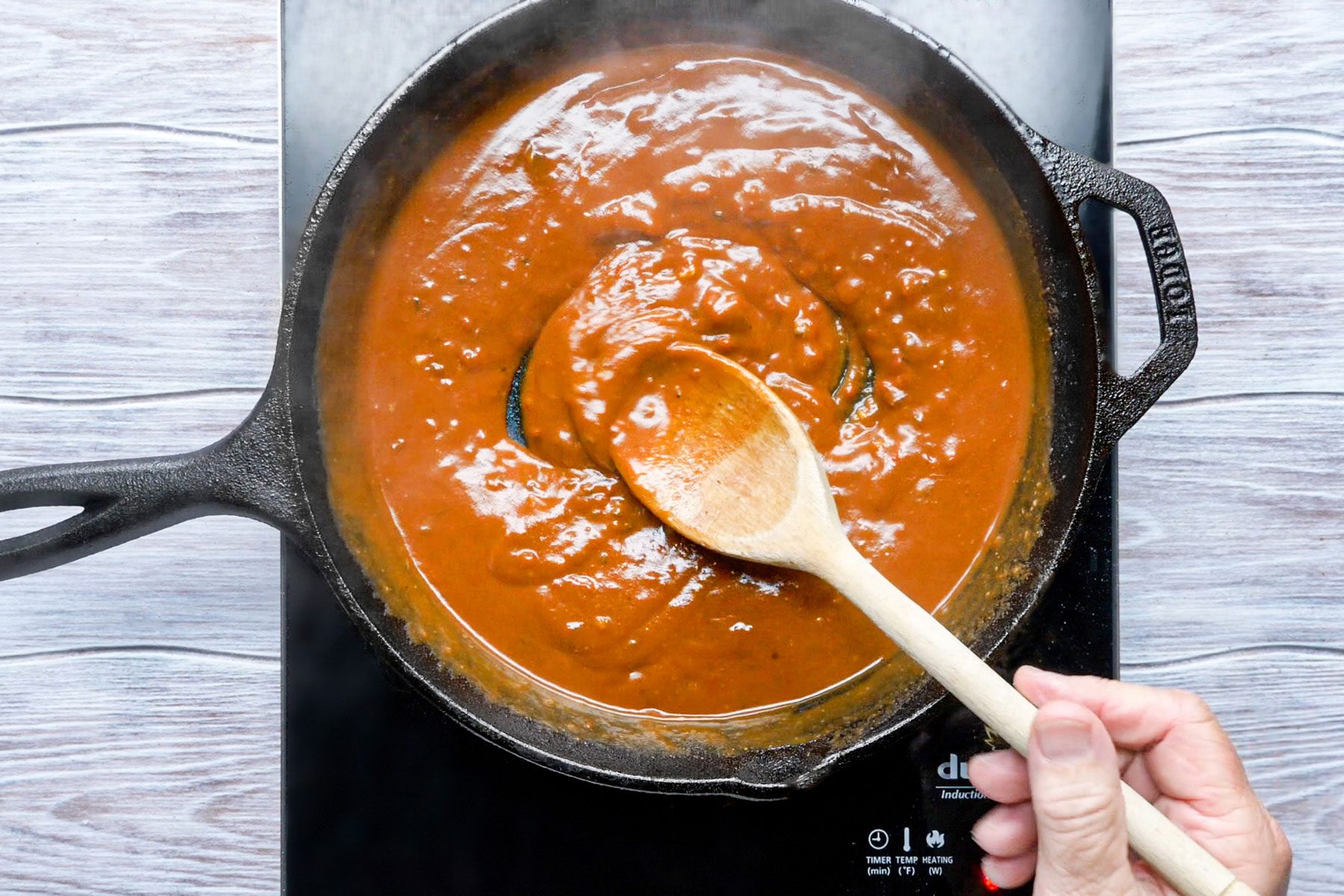 Stirring the mixture in a large skillet with a big spoon