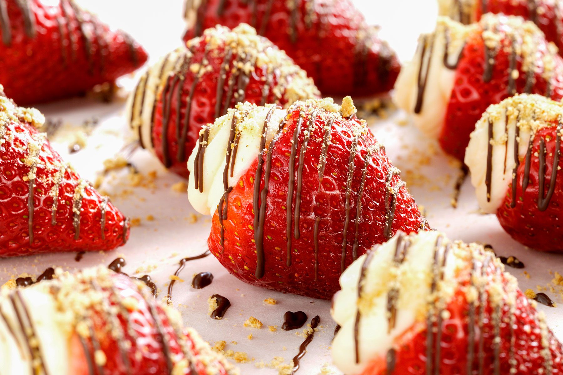 Angular shot of Strawberry Cheesecake Bites with drizzled chocolate