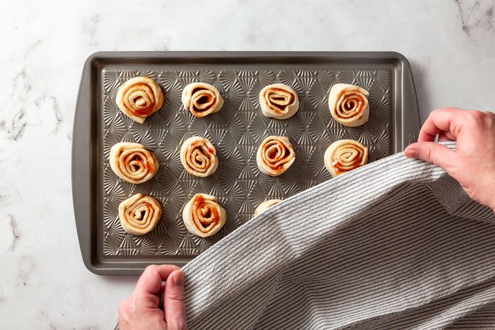 Slices of dough rolled up and placed on baking sheet