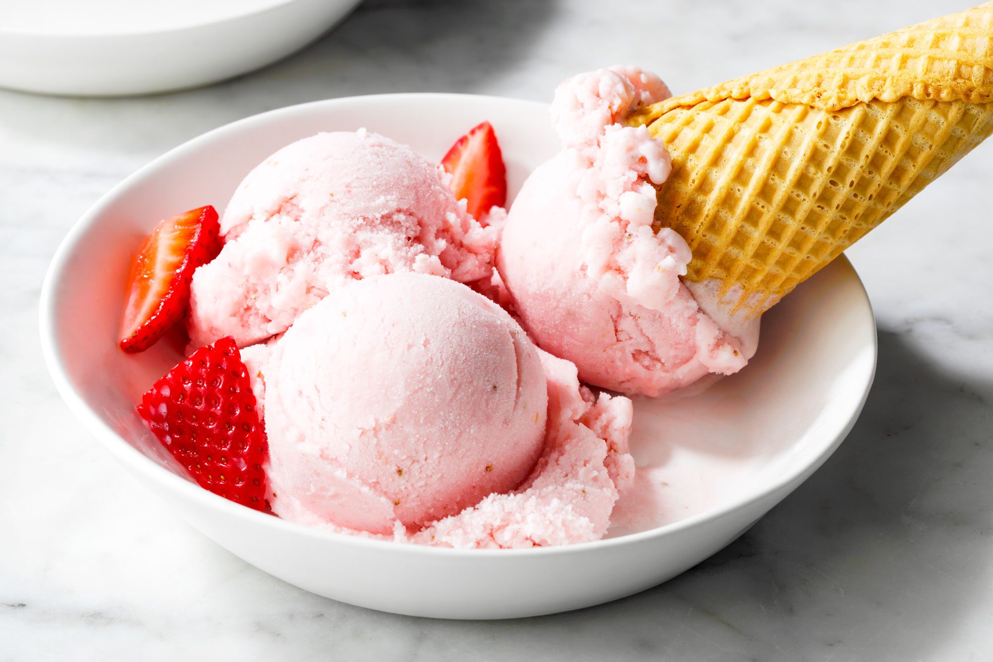 close shot of strawberry gelato in a small bowl; marble surface;