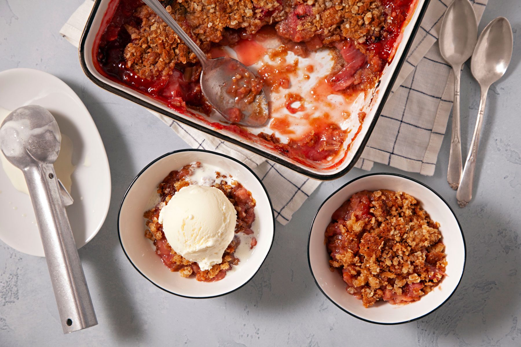 A bowl of Strawberry Rhubarb Crisp served with vanilla ice cream