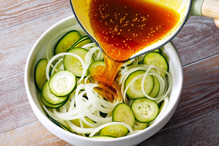 wide shot of pickles mix Poured over cucumber and onions