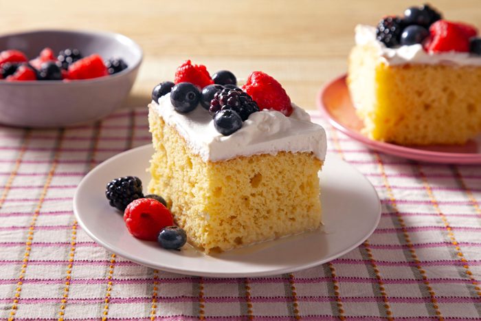 Easy Tres Leches Cake slice on a plate topped with berries