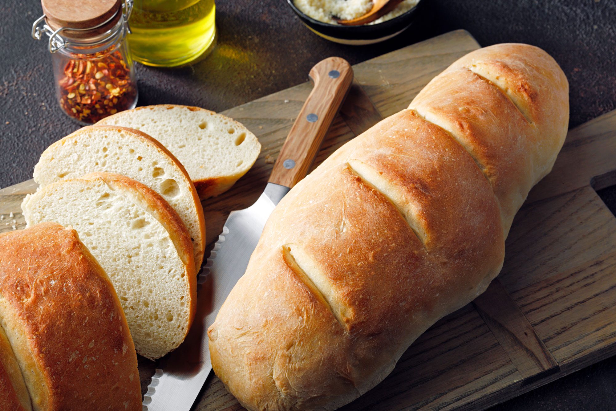 Freshly baked Mom's Italian Bread loaf on a cutting board with a knife