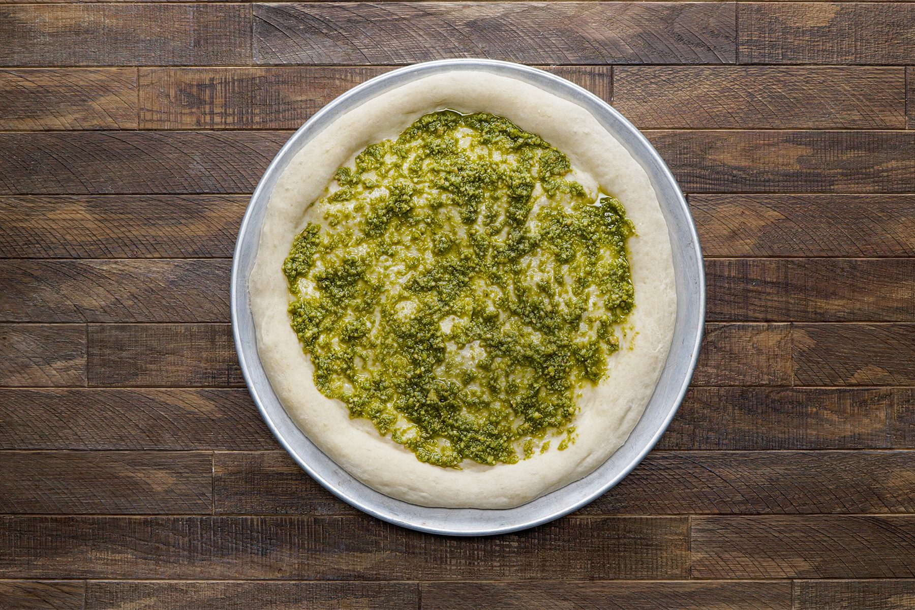 Pesto spread over the crust