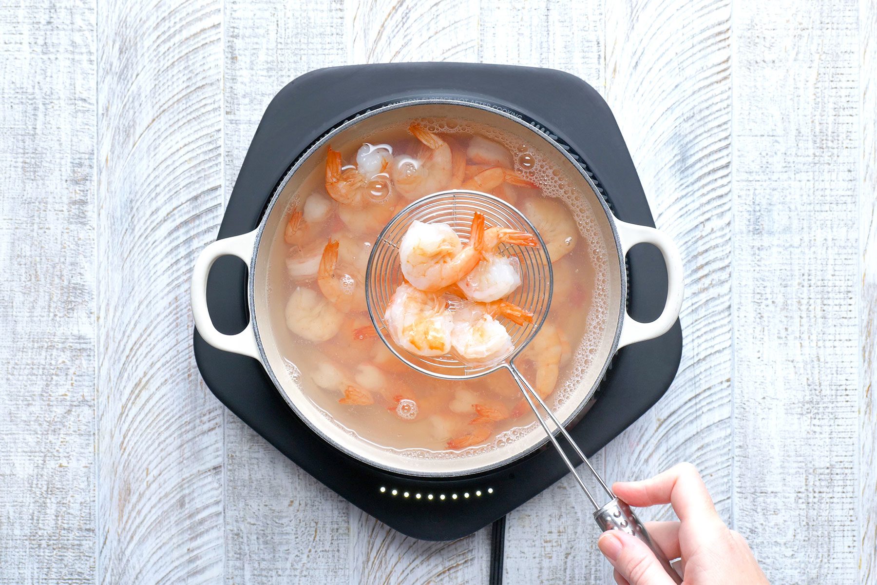overhead shot of drained shrimps in a saucepan