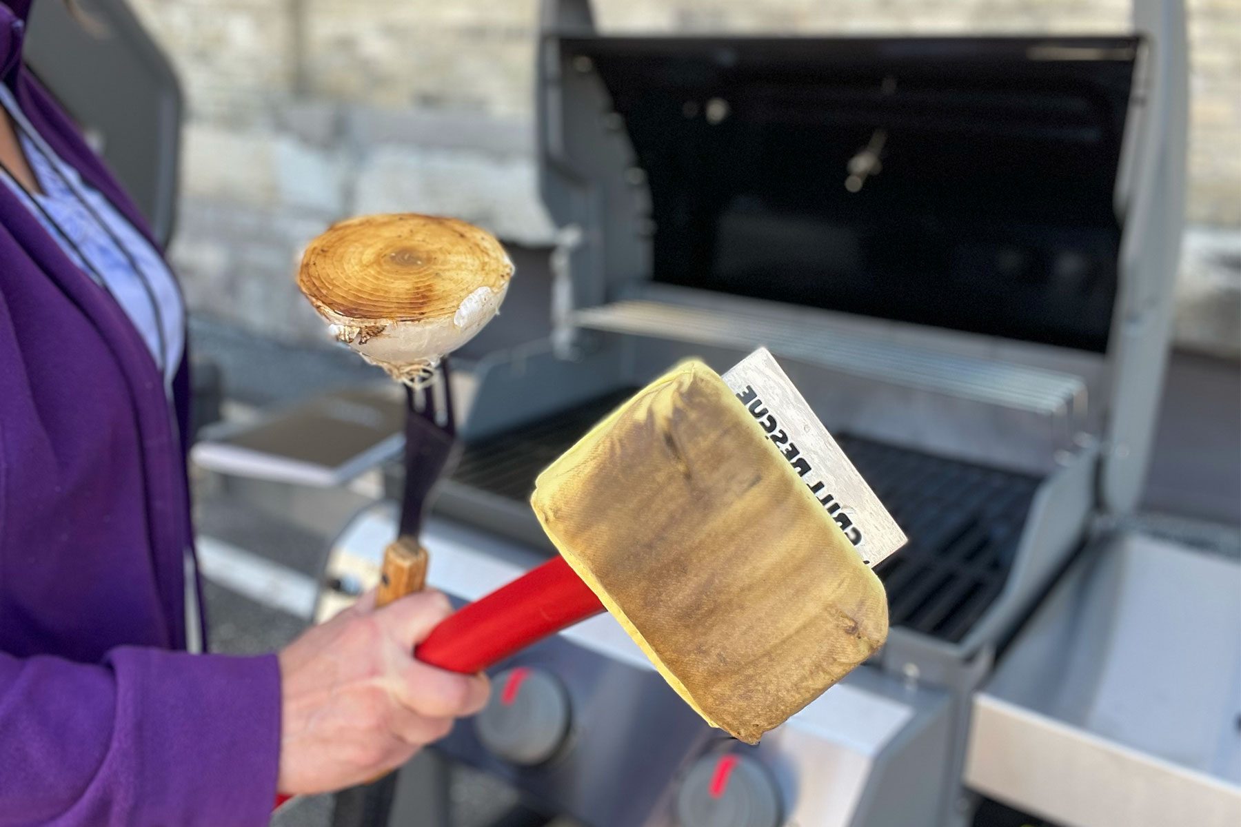 woman holding grill cleaner and half cut onion on a tong