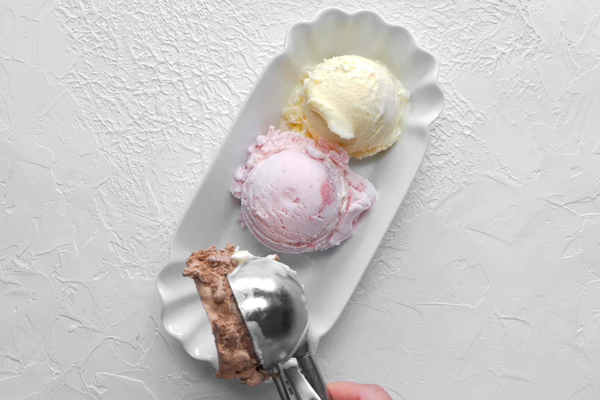 overhead shot; white background; Placing ice cream in a dessert dish;
