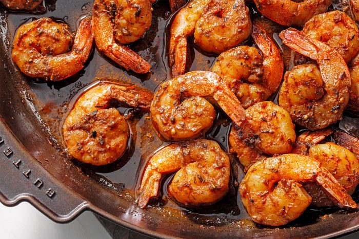 Close shot of Blackened Shirmp; wooden base; kitchen towel; white marble background;