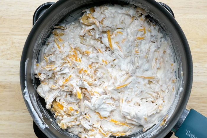 Cream of mushroom soup mixed with cheese and other ingredients in a saucepan