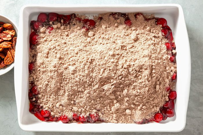 Overhead shot of cake mix spread in a greased baking dish