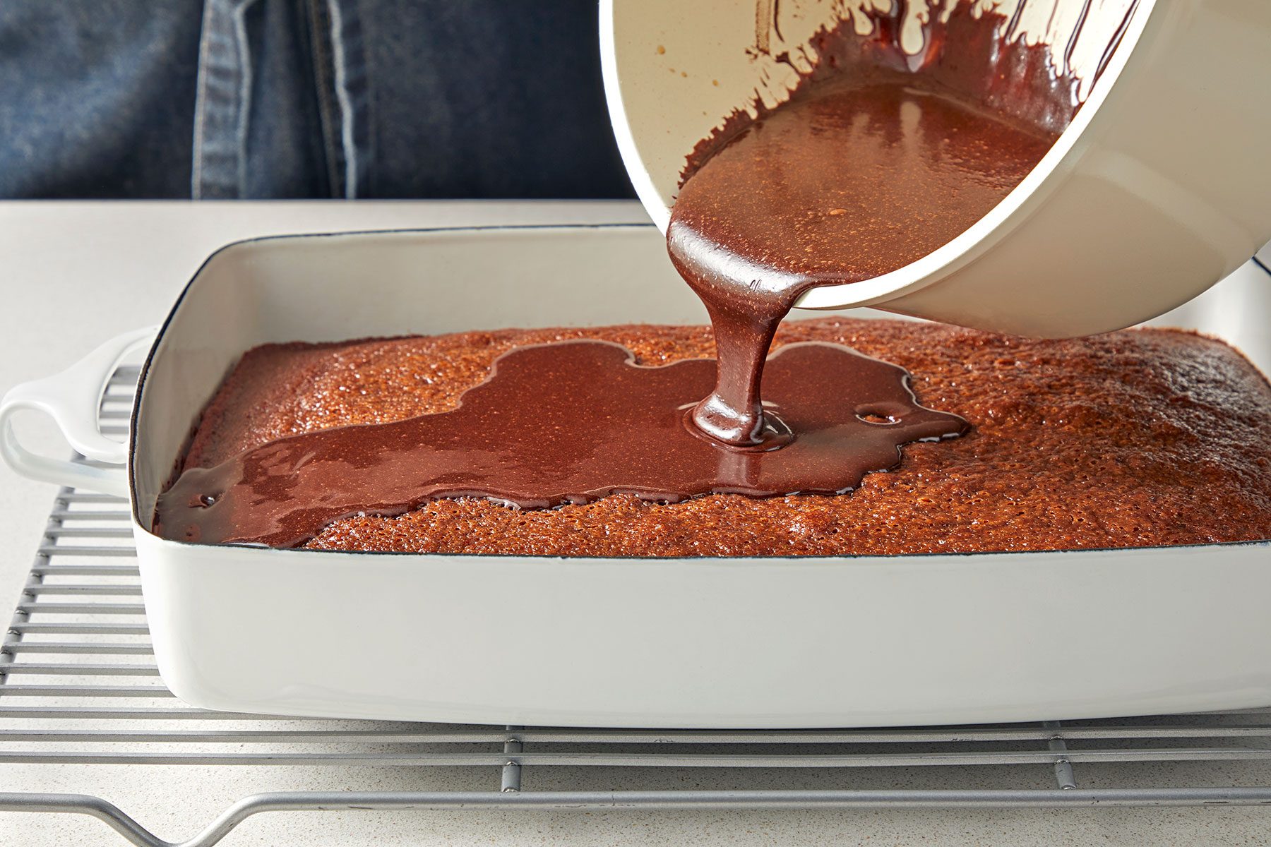 close shot of cocoa mix added on the cake over the prepared baking dish